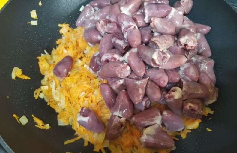 Курячі сердечка з овочами та макаронами на сковороді