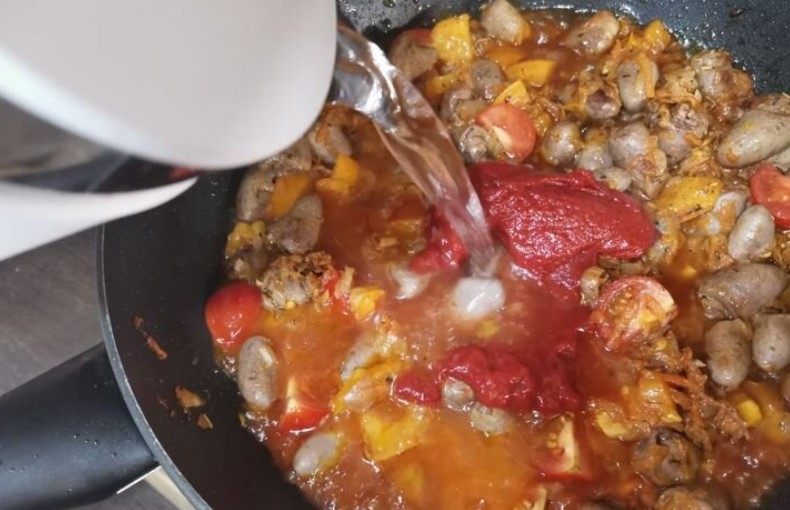 Курячі сердечка з овочами та макаронами на сковороді